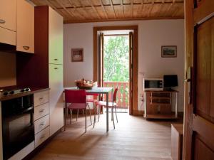 una cucina con tavolo, sedie e finestra di Studio apartment with air conditioning a Ceresole Reale