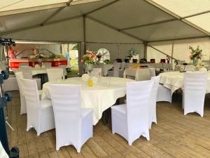 ein Zelt mit weißen Tischen und Stühlen in der Unterkunft Family-Friendly Guesthouse in the Oderbruch in Genschmar