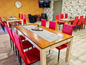 ein Esszimmer mit Tischen und roten Stühlen in der Unterkunft Cosy apartment in the Oderbruch in Genschmar