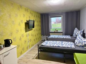 two beds in a room with yellow walls at Family-Friendly Guesthouse in the Oderbruch in Genschmar