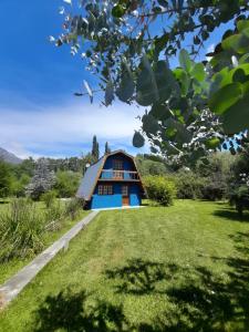 een blauw huis met een rieten dak bij Cabañas La Portada in El Bolsón +9 foto's