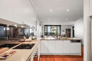 a kitchen with white cabinets and a stove top oven at Cscape3 in Cowes