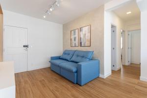 a blue couch in a living room with wood floors at Apto Reformado e Moderno com Vista Mar no Centro in Florianópolis