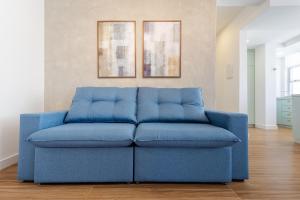 a blue couch sitting in a living room at Apto Reformado e Moderno com Vista Mar no Centro in Florianópolis
