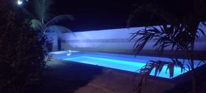 a swimming pool in a yard at night at Unique Owl Apartments in Sanyang