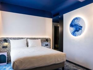 a bedroom with a bed with a blue ceiling at Mercure Bucharest Cantemir in Bucharest +54 photos
