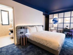 a hotel room with a bed and a desk at Mercure Bucharest Cantemir in Bucharest