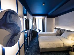 een hotelkamer met 2 bedden en een schilderij aan de muur bij Mercure Bucharest Cantemir in Boekarest +33 foto's