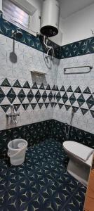 een badkamer met zwart-wit betegelde muren en een toilet bij La Nature Retreat in Kuilapayam
