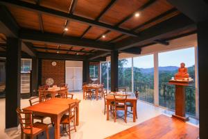 een eetkamer met tafels en stoelen en een groot raam bij Ivory Canopy Resort - Ella in Ella