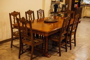 een houten eettafel met stoelen en een glazen schaal erop. bij Escape to Villa Serena - with a Hidden Speakeasy in Dahlonega