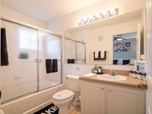 a bathroom with a toilet and a shower and a sink at The Enchanted luxe Townhome in Kissimmee +45 photos