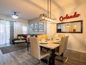 a dining room and living room with a dining table at The Enchanted luxe Townhome in Kissimmee