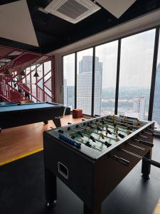 a large pool table in a room with windows at Kampung Marsa at Majestic Residence, Kuala Lumpur in Kuala Lumpur