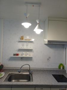 a kitchen with a sink and two lights above it at Melodia Pension in Geoje  +73 photos