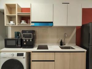 a kitchen with a sink and a washing machine at Kampung Marsa at Majestic Residence, Kuala Lumpur in Kuala Lumpur