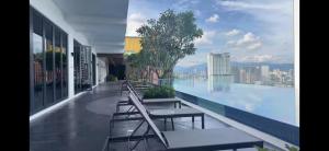 a balcony with chairs and a swimming pool on a building at Kampung Marsa at Majestic Residence, Kuala Lumpur in Kuala Lumpur