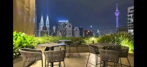 a patio with tables and chairs and a city skyline at Kampung Marsa at Majestic Residence, Kuala Lumpur in Kuala Lumpur