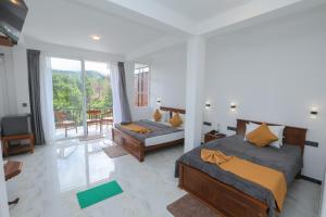 een slaapkamer met twee bedden en een balkon bij Ivory Canopy Resort - Ella in Ella