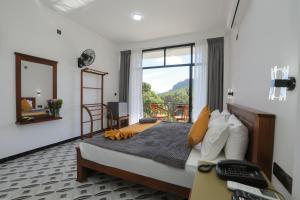 een slaapkamer met een bed, een raam en een bureau bij Ivory Canopy Resort - Ella in Ella