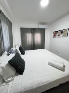 ein Schlafzimmer mit einem großen weißen Bett und Kissen in der Unterkunft Oasis Costa Cana in Punta Cana in Punta Cana + 16 Fotos