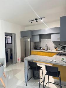 eine Küche mit einer Theke und ein paar Stühlen darin in der Unterkunft Oasis Costa Cana in Punta Cana in Punta Cana