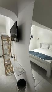 a bedroom with a bed and a tv on a wall at Yasemin Pansiyon Plus in Seferihisar