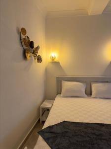 a bedroom with a bed with a butterfly clock on the wall at Yasemin Pansiyon Plus in Seferihisar
