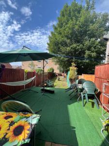 patio con ombrellone e sedie su prato di room near Luton center a Luton