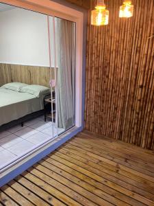 a room with a bed and a glass window at Casa no Centrinho para 2 pessoas 100m do Mar in Bombinhas