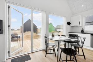 una cucina e una sala da pranzo con tavolo e sedie di 949-Hvide-Sande-Langsand-161 a Hvide Sande