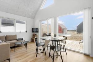 un soggiorno con tavolo, sedie e divano di 949-Hvide-Sande-Langsand-161 a Hvide Sande