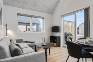 un salon avec un canapé et une table dans l'établissement 9951-Hvide-Sande-Langsand-206, à Hvide Sande