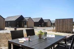 une table en bois devant un groupe de maisons dans l'établissement 9951-Hvide-Sande-Langsand-206, à Hvide Sande