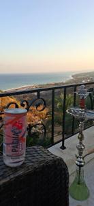 a drink on a table on a balcony with the ocean at Honey Chalet in Al Khayyām