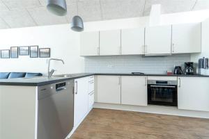 een witte keuken met witte kasten en een spoelbak bij 903-Hvide-Sande-Langsand-94 in Hvide Sande +43 foto's