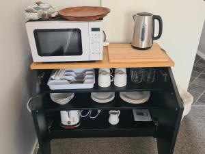 een magnetron die bovenop een plank staat bij Lanark Mews in Te Kopuru