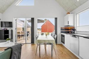 una cucina e una sala da pranzo con tavolo e sedie di 945-Hvide-Sande-Langsand-163 a Hvide Sande