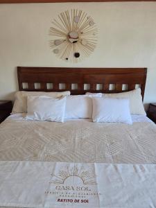 a large bed with a large clock on the wall at Loft Rayito de Sol, Zihuatanejo Center with AC in Zihuatanejo