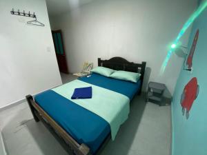 a bedroom with a bed with a blue comforter at Fauna in Santa Marta