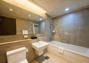 a bathroom with a toilet and a sink and a tub at W Residence Hotel in Busan +83 photos