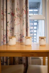 tre vasi su un tavolo di legno con una finestra di Cozy home a Kings Lynn Altre 6 foto
