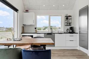 een keuken met een houten tafel en een keuken met witte kasten bij 947-Hvide-Sande-Langsand-228 in Hvide Sande