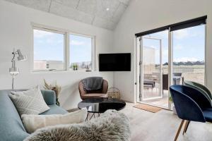 een woonkamer met een bank, stoelen en een tv bij 947-Hvide-Sande-Langsand-228 in Hvide Sande
