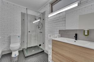 een badkamer met een douche, een toilet en een wastafel bij Snobs Creek Motel Eildon in Eildon +15 foto's