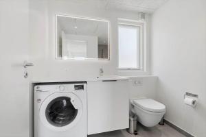 een witte badkamer met een wasmachine en een toilet bij 947-Hvide-Sande-Langsand-228 in Hvide Sande +28 foto's