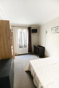 a hotel room with a bed and a desk at Au Fleuri hotel in Paris