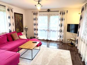 a living room with a pink couch and a table at Domek Maria Mąka in Zakopane