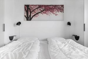 une chambre avec un lit blanc et un tableau au mur dans l'établissement 917-Hvide-Sande-Langsand-176-stuen, à Hvide Sande