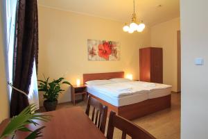 1 dormitorio con cama, mesa y comedor en Penzion U Čejpu en Praga